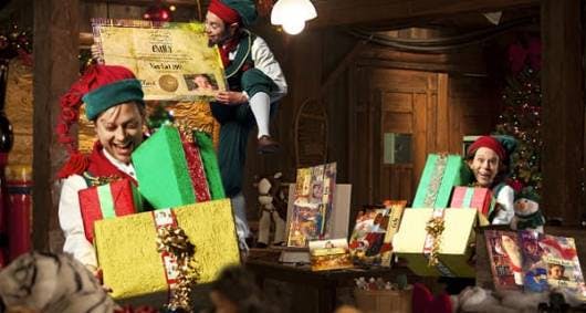 Explore the magical wonders of Santa's Village in the North Pole with Mrs. Claus' photo of elves with gifts, there's a lot of work to do before Christmas!
